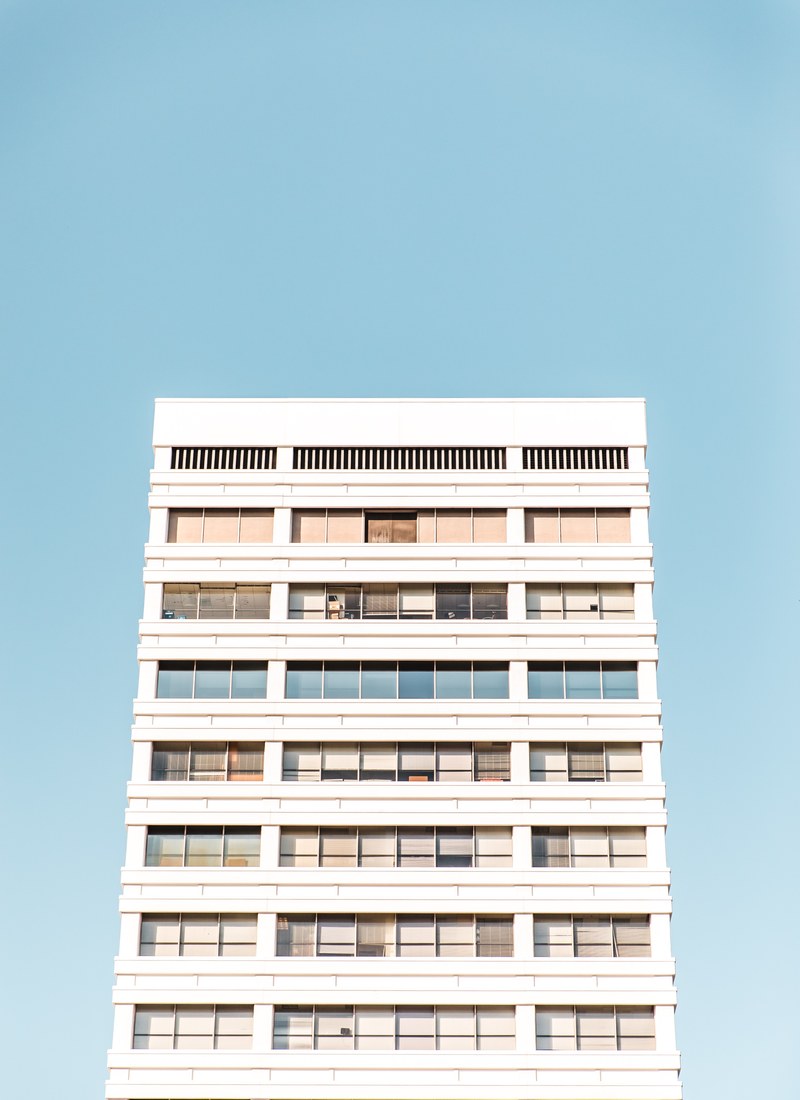 a white residential building against a pale blue sky, abstract livin 4k