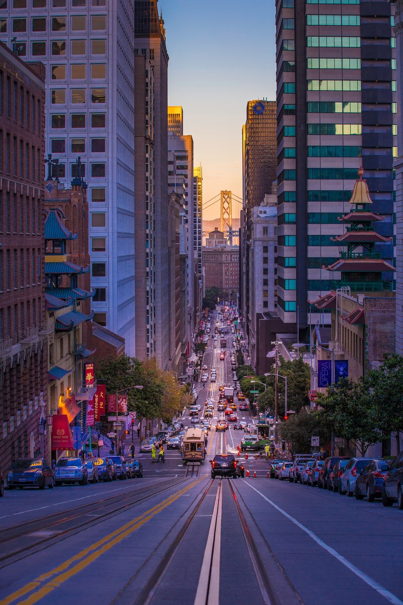 sloped downtown city street in san francisco with tram traffic and skyscrapers california street at dusk, sloped view california street 4k