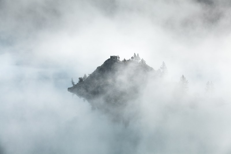 mountain peak in emerald bay peeks through morning mist, foggy mountain weather 4k