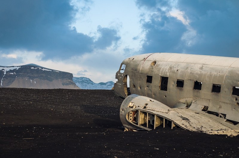 abandoned airplane wreckage by a mountain landscape, desert plane crash 4k