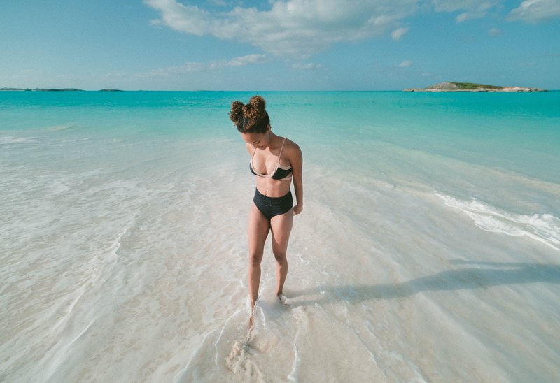 woman in bikini on a tropical beach at exuma, toes in the sand 4k