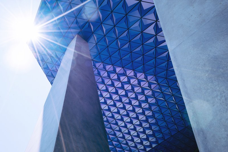 a lens flare over an overhang in the facade of a modern building, angles in architecture 4k