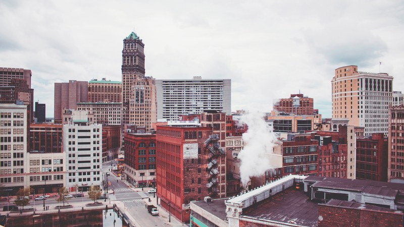 drone view of downtown buildings in detroit of different architectural styles with smoke, buildings downtown detroit 4k