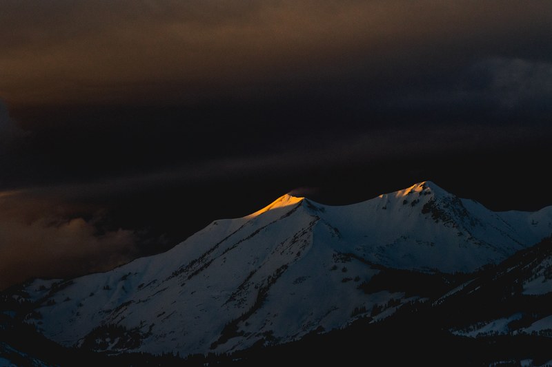 the last rays of sun on the peaks of a snowy mountain at dusk, last light_ 4k