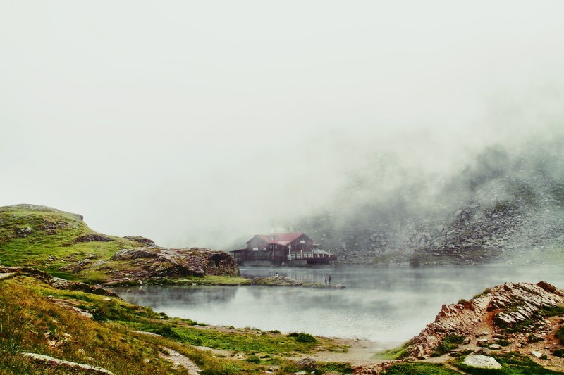 rustic cabin on a serene lake surrounded by mountains, cloudy cabin escape 4k
