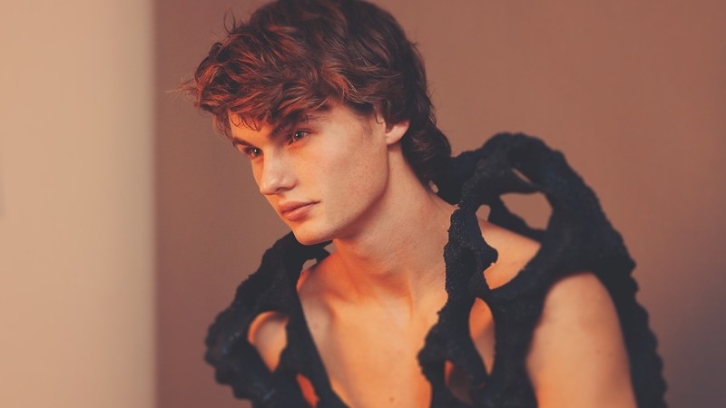 a male model shot by nick karvounis photography wears an open black garment revealing his chest, male model in open garment 4k