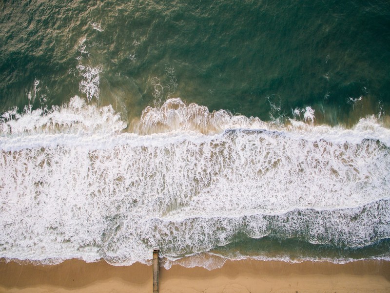 drone view of ocean waves washing on the sand beach shoreline at redondo beach, ocean washing on sand beach 4k