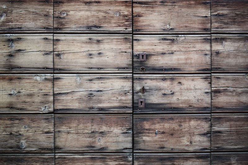 two locks on a wood paneled aged door in vigevano, hidden door 4k