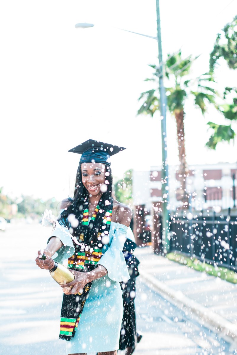 a woman in a graduation cap opening a bottle of champagne, popping bottles 4k
