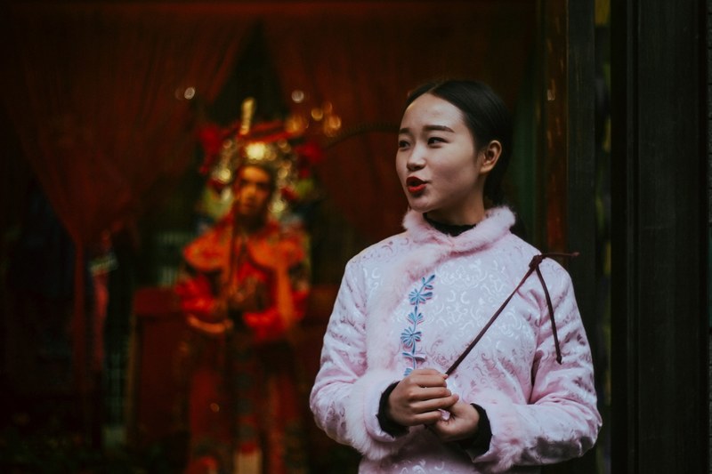 happy young woman in pink stands outside an asian temple, by the temple 4k