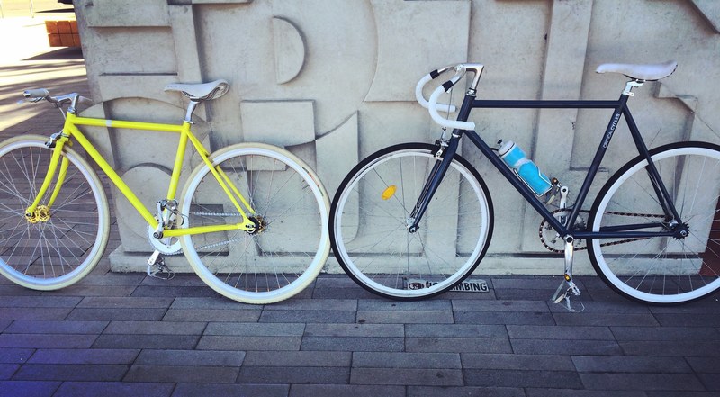 a yellow bike and a blue bike with a blue water bottle leaning against a wall in san diego, san diego bicycles 4k