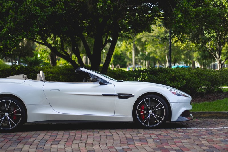 a white sports convertible parked near a park, white convertible near a park 4k
