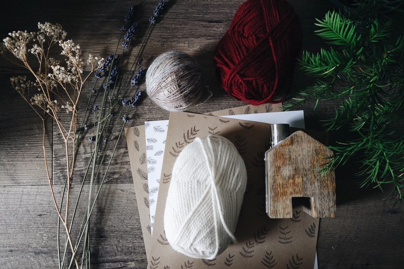 a bunch of flowering grasses next to a pine branchlet and three balls of yarn, flatlay with balls of yarn 4k