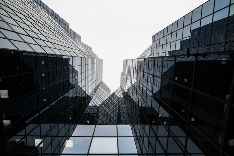 a low angle shot of the reflective glass facade of a skyscraper in montreal, reflective skyscraper facade 4k