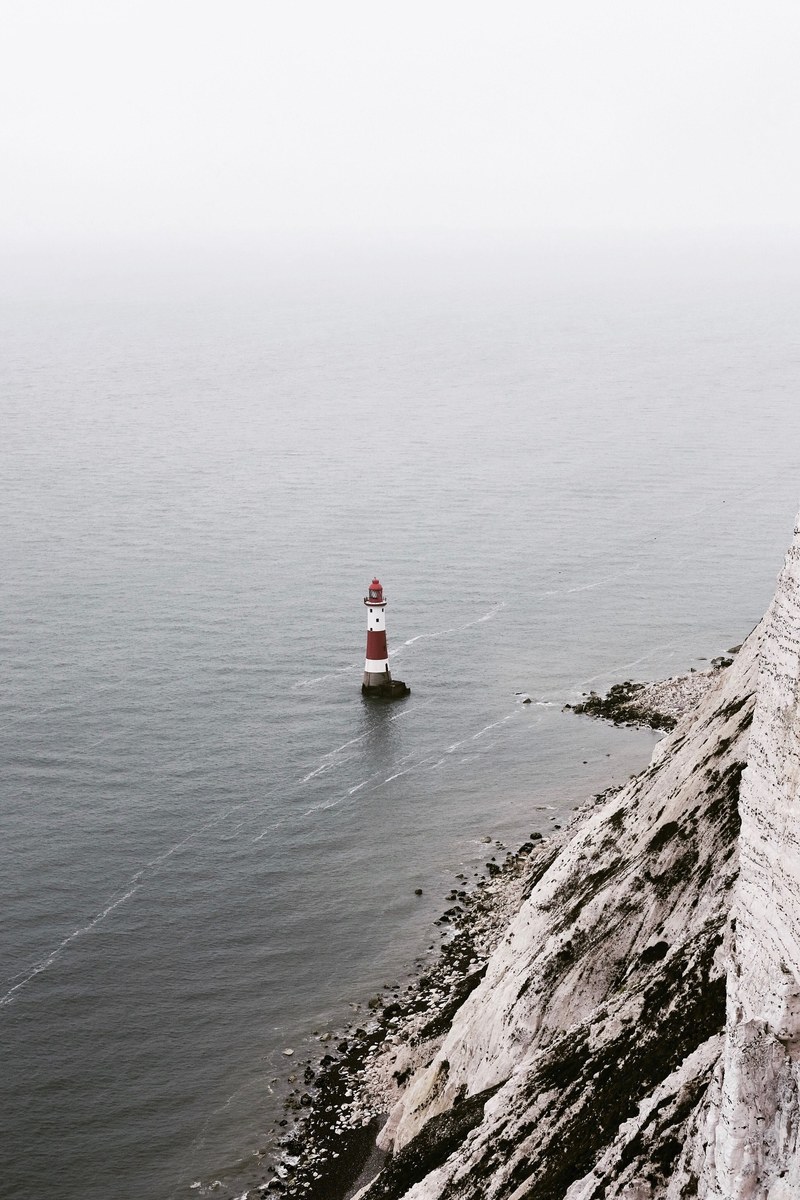 a cliff and a lighthouse at beachy head, cliff edge 4k
