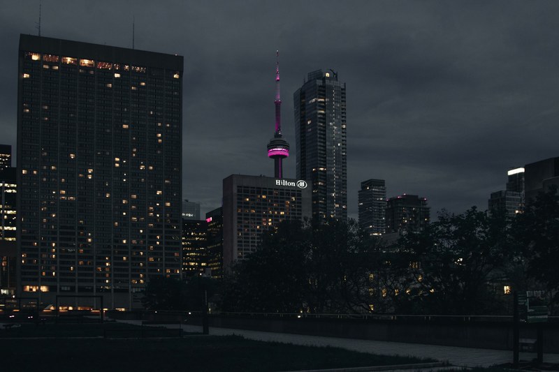 a dim cityscape of toronto with the cn tower lit up in purple, toronto night cityscape 4k