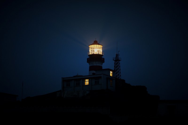 a lighthouse at night shining a light, lighthouse at night 4k