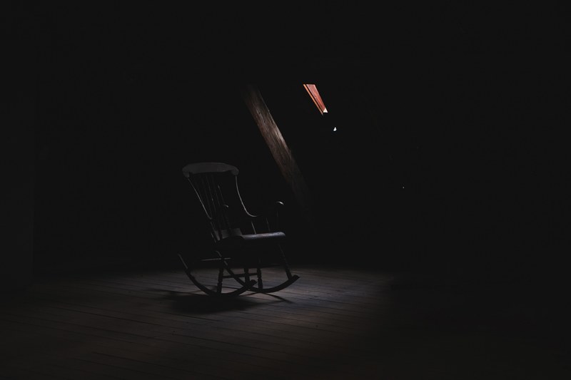 single black rocking chair in middle of dark room in copenhagen, black rocking chair 4k