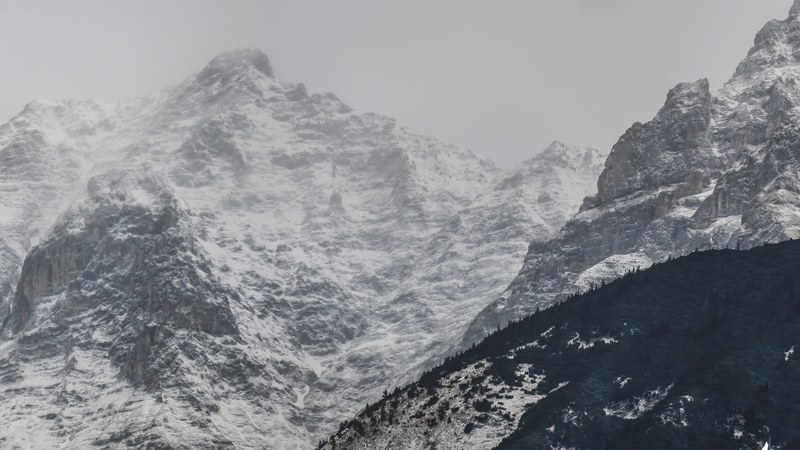 a jagged mountain face enveloped in a faint mist, dont be afraid to let go_ 4k