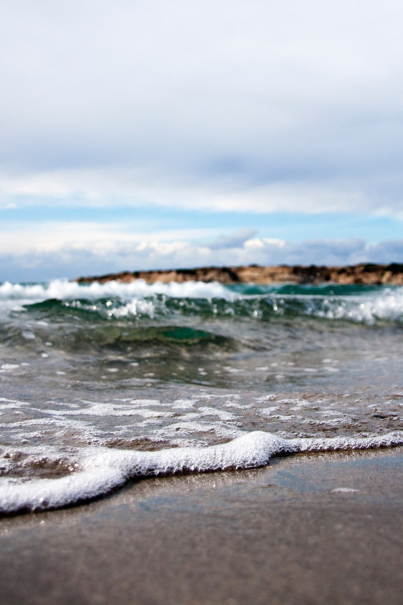 the ocean tide is vibrant and washes off on the beach shore on a cool summer day, ocean wave race to beach shore 4k