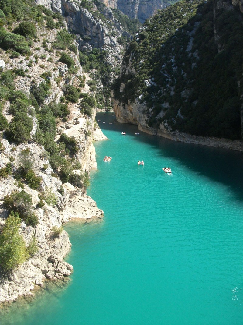 boats on turquoise water in a white rock canyon, sailing along the canyon 4k