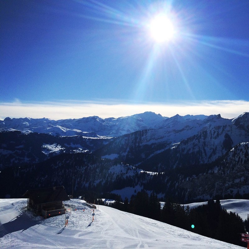 a view on a snowy mountain resort with the sun high in the sky, mountain resort in chalberhni 4k