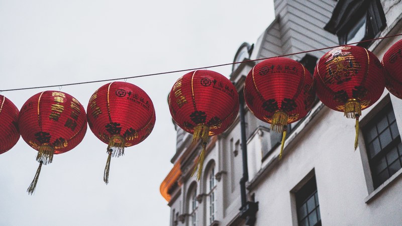 row of red chinese lanterns hanging above a street, _day 28 unsplashdaily 4k