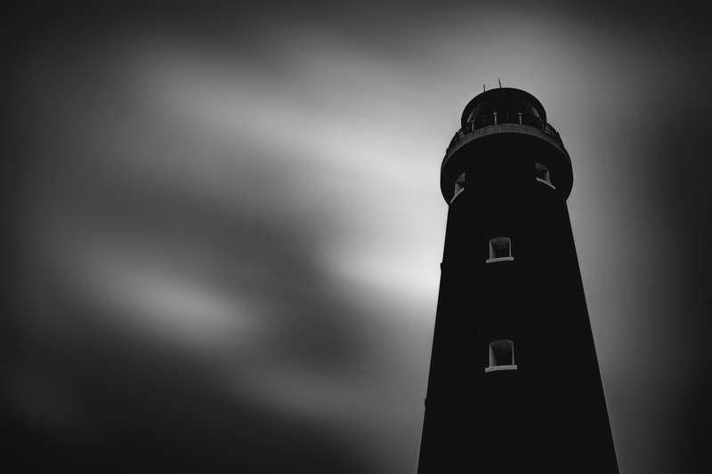 black and white shot of traditional lighthouse against cloudy sky, cloudy sky and lighthouse 4k