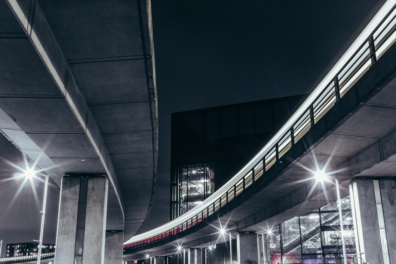 bright lights under a curving overpass in copenhagen at night, metro 4k