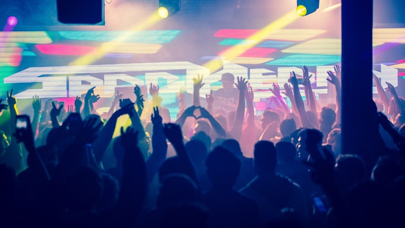 crowd with raised arms in a colorful club in silhouette, spag heddy 4k