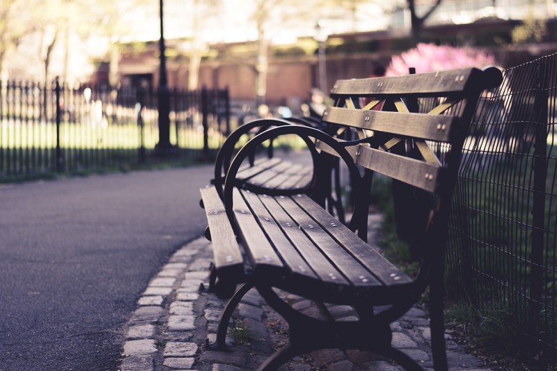 two empty benches on the side of a fenced park path on a sunny day, empty benches 4k