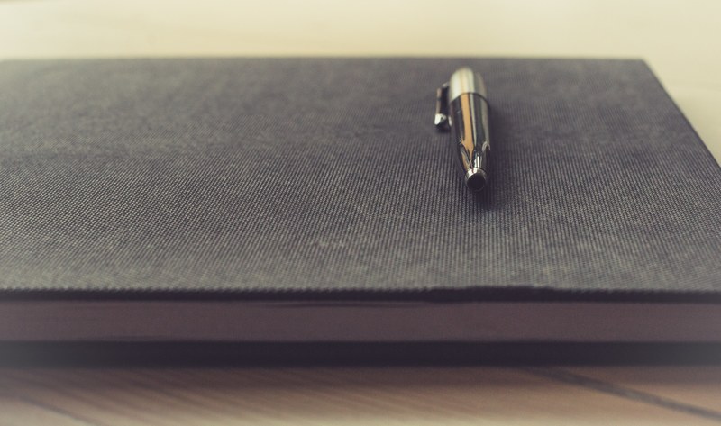 close up of a pen on a black notebook, pen on a notebook 4k