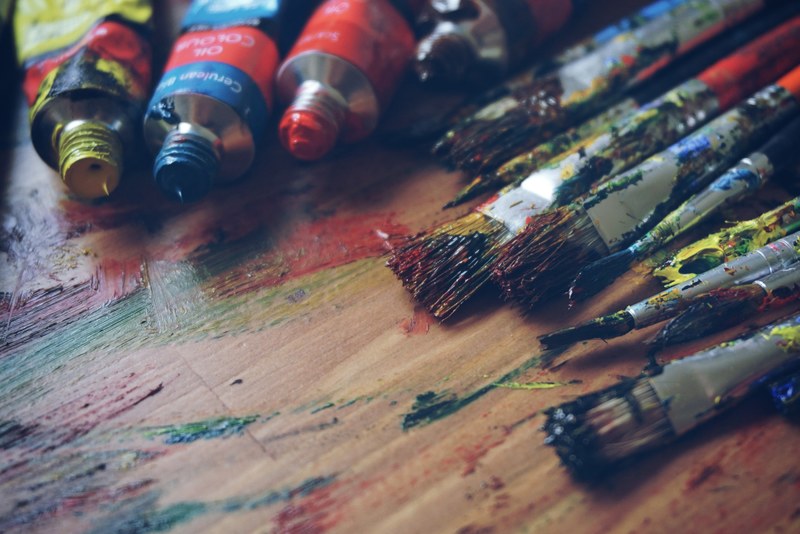 close up of paint tubes brushes and bristles with smeared painted on table ljubljana, messy paint brushes 4k