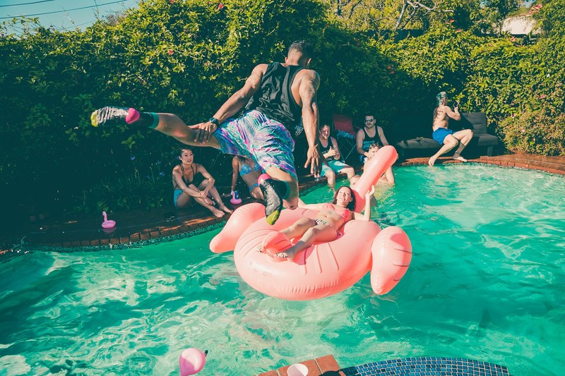 a man diving into a pool at a party, _pool party diving 4k