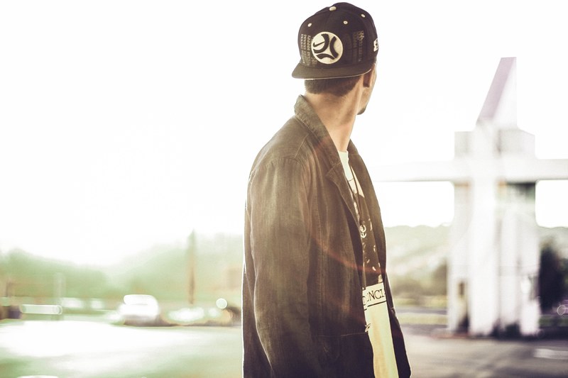 person wearing a jacket and a baseball hat looking away, looking away from the camera 4k