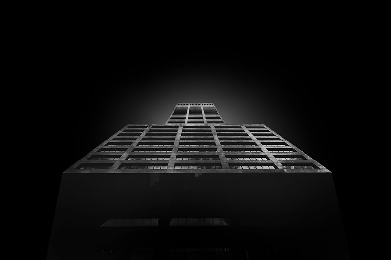 black and white shot from below of building architecture and light glow on black background, black building from below 4k
