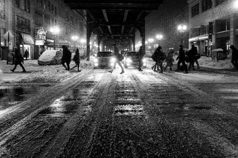 black and white shot of people walking in city street slush with snow and cars, walking in city slush 4k