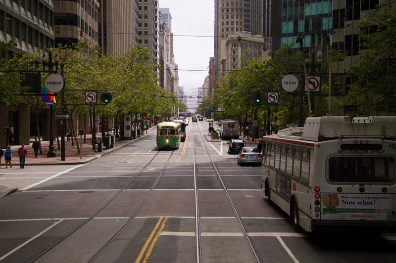 an urban street with trolley tracks and a green trolley car, the streets of fremont 4k
