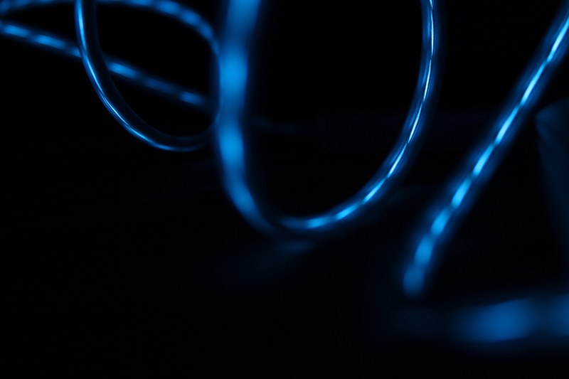 blue light reflected in the surface of glossy swirling wires, blue light on glossy wires 4k