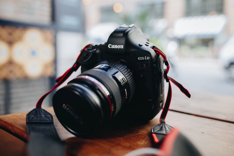 a long lens canon camera on a wooden surface, long lens camera in close up 4k
