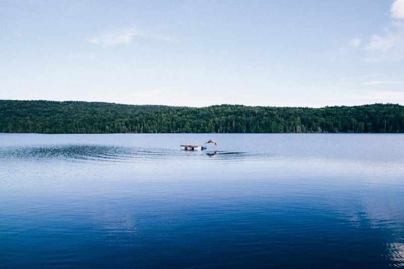 a person leaping into the water from a platform in the middle of a lake, timing is key 4k
