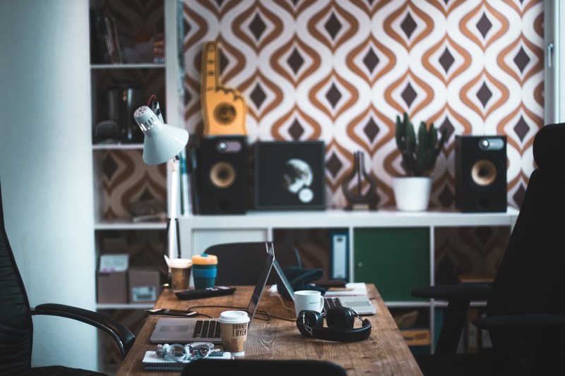 a busy desk with two macbooks and two office chairs in a workspace, two person workspace 4k
