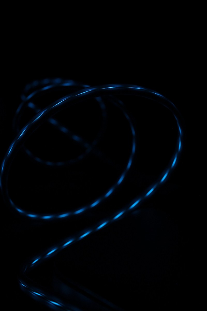 blue light reflected in the glossy surface of a swirling wire, swirling glossy wire 4k