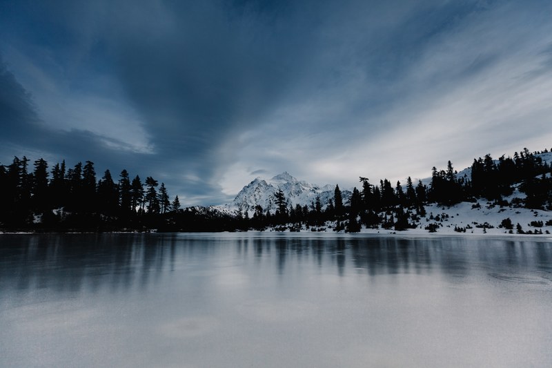 frozen lake on a winter day with mountains and trees in the background, frozen lake on a winter day 4k