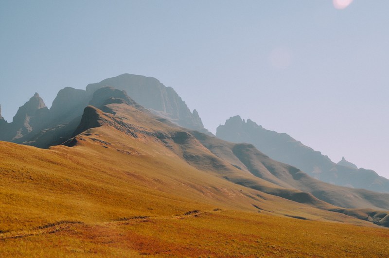 ascent to a mountainous hill with orange ocher ground on a cloudless day, mountain hill ridge 4k