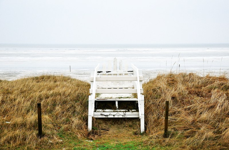 white wooden gate on the grass by the sand beach at cuxhaven, wooden gate at the beach 4k