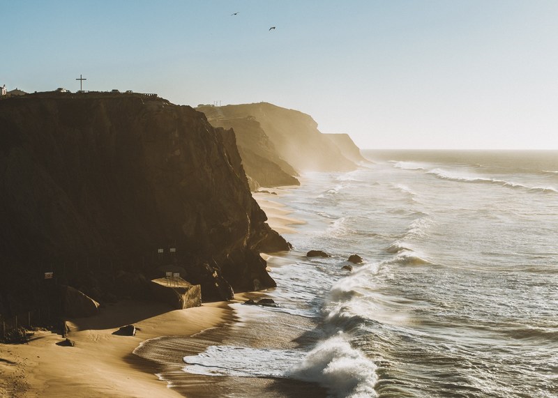 ocean waves crashing on the sand beach with cliffs in santa cruz, ocean crashing on beach 4k