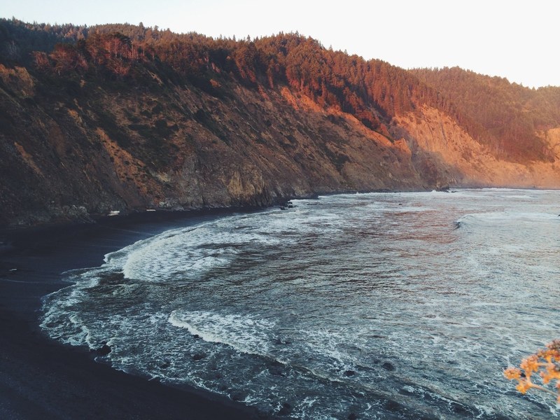 a scenic view of a bay cutting into the rocky wooded coastline, bay under the forested cliff 4k