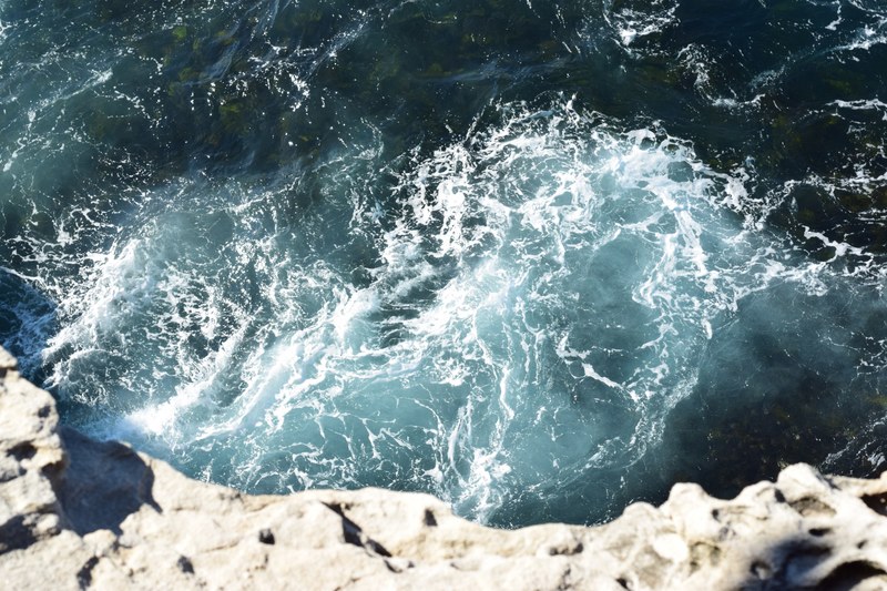 view of the ocean crashing on the shore from a cliff at bondi beach, cliff view of ocean crashing 4k
