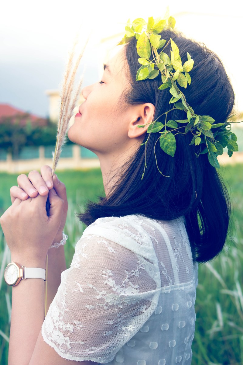 woman with a leaf flower crown smelling grains of wheat, one with nature 4k